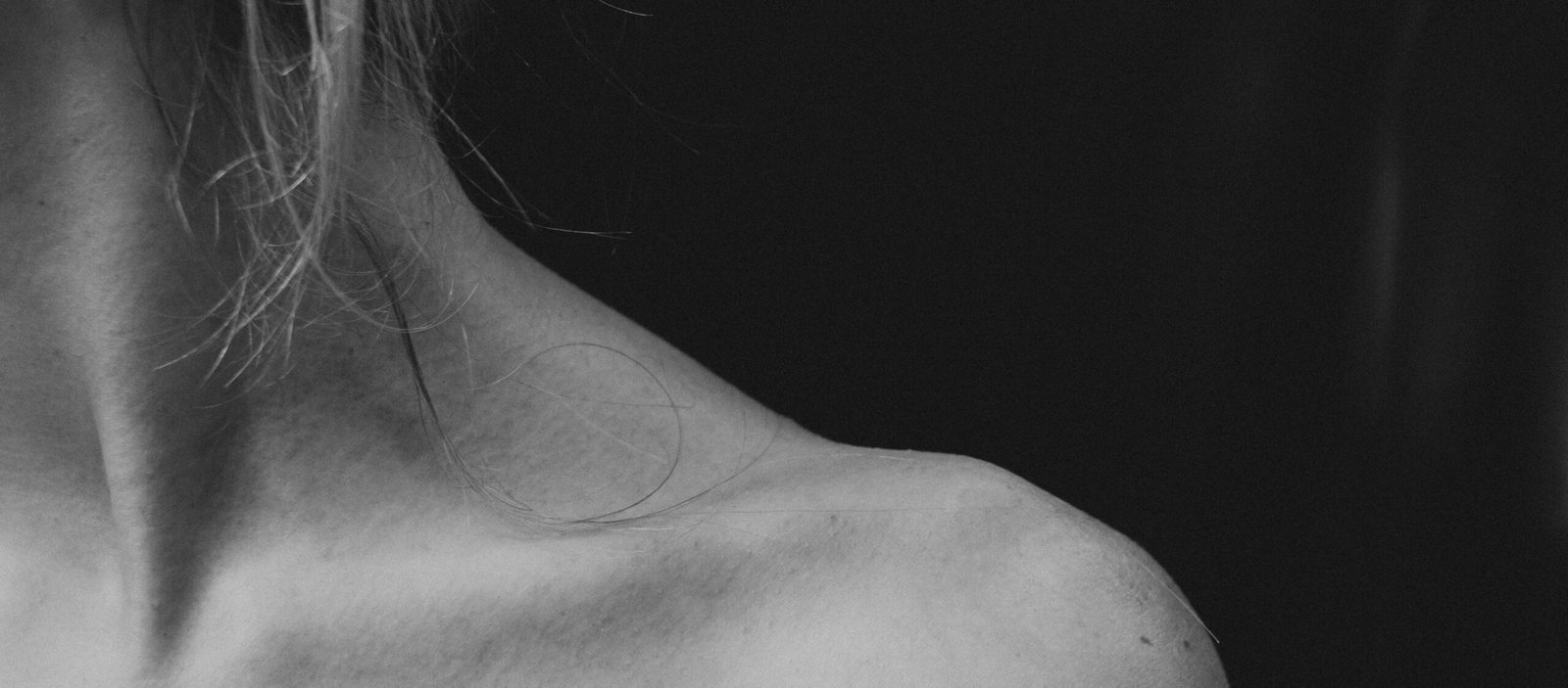 An artistic photo of a nude woman solo, where dramatic light and shadow sculpt her form, exploring themes of vulnerability and strength in art.