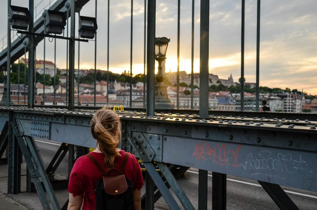 A traveler looks out over a beautiful European cityscape at sunrise, representing the perfect adventure in one of the good European cities to visit.