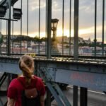 A traveler looks out over a beautiful European cityscape at sunrise, representing the perfect adventure in one of the good European cities to visit.