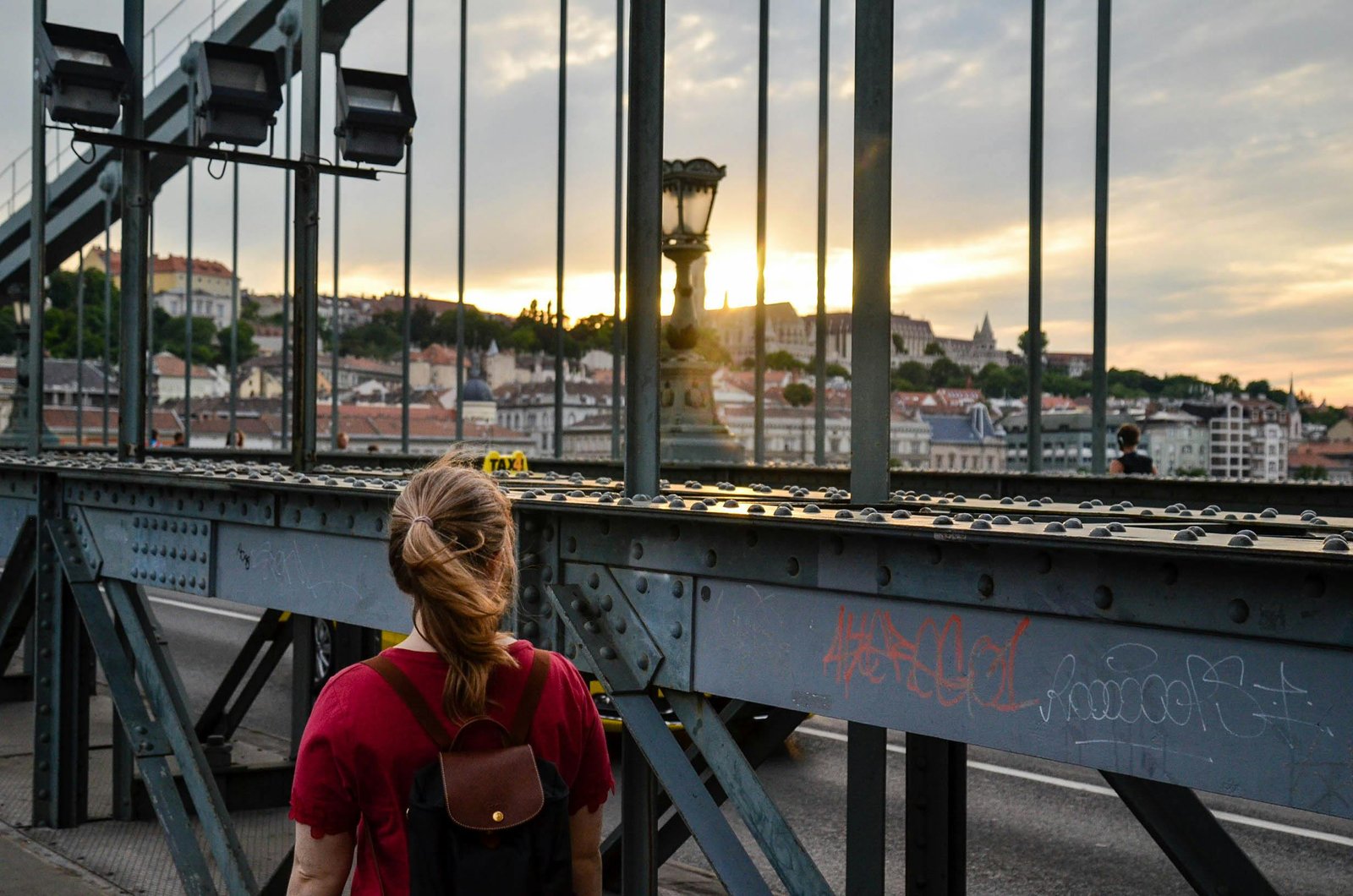 A traveler looks out over a beautiful European cityscape at sunrise, representing the perfect adventure in one of the good European cities to visit.