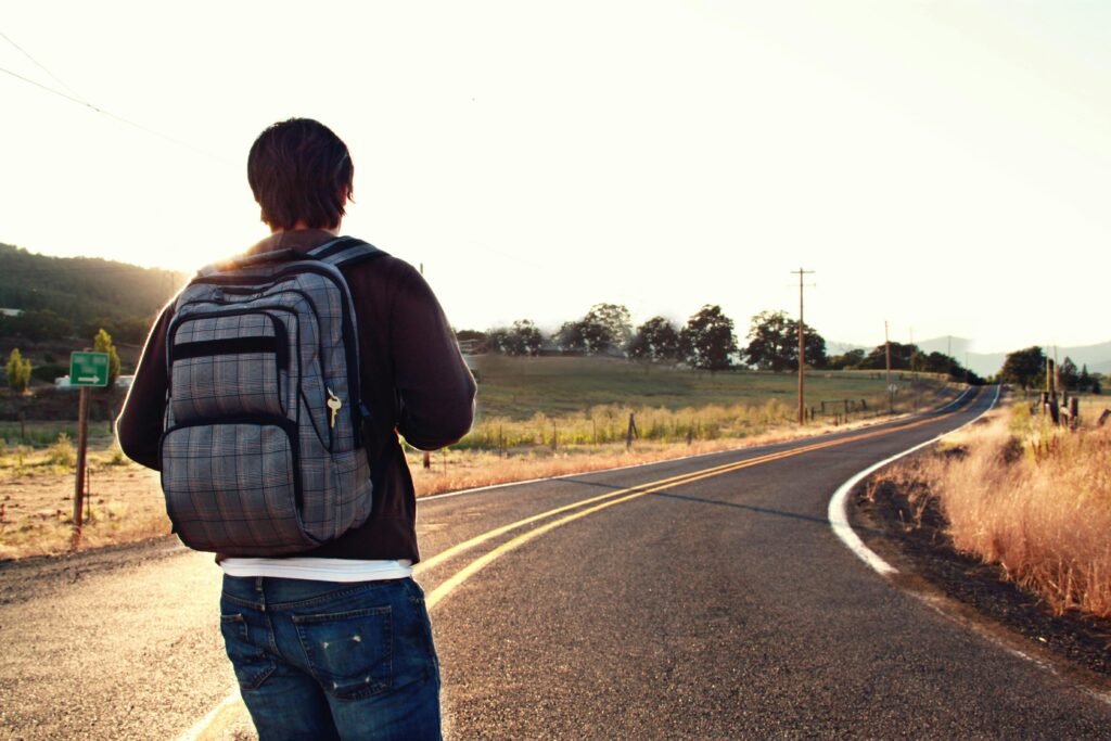 Solo traveler with a backpack looking at a breathtaking view, representing freedom, self-discovery, and smart ways to find solo travel deals.