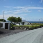 A scenic road winding along the dramatic, green cliffs of the Irish coast, representing the best things to see in Ireland on a road trip.