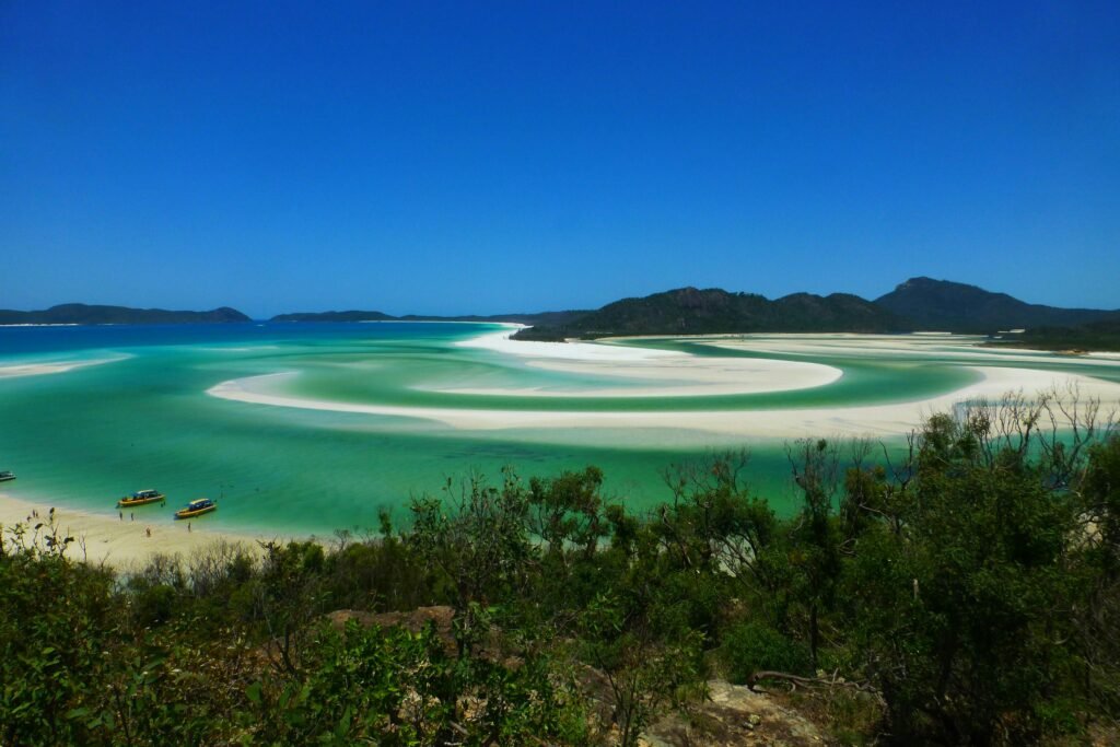 Aerial view of the swirling turquoise waters and pristine white sand of Whitehaven Beach in the Whitsundays, one of the best places to visit in Australia for a stunning adventure.