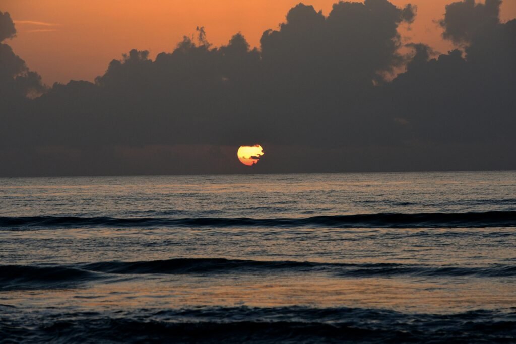 A serene, wide sandy beach on the Texas Gulf Coast at sunset, showcasing one of the best beach destinations in Texas for a vacation.