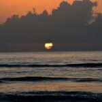 A serene, wide sandy beach on the Texas Gulf Coast at sunset, showcasing one of the best beach destinations in Texas for a vacation.