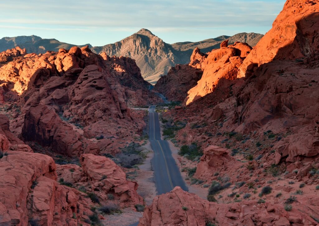 The sun sets over the vast Las Vegas desert, casting a warm glow on the iconic red rock formations of the Mojave.