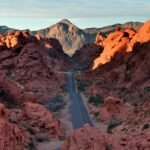 The sun sets over the vast Las Vegas desert, casting a warm glow on the iconic red rock formations of the Mojave.