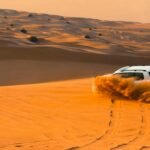 Dubai desert safari adventure with golden sand dunes at sunset and a camel caravan, ideal for an unforgettable Arabian journey.