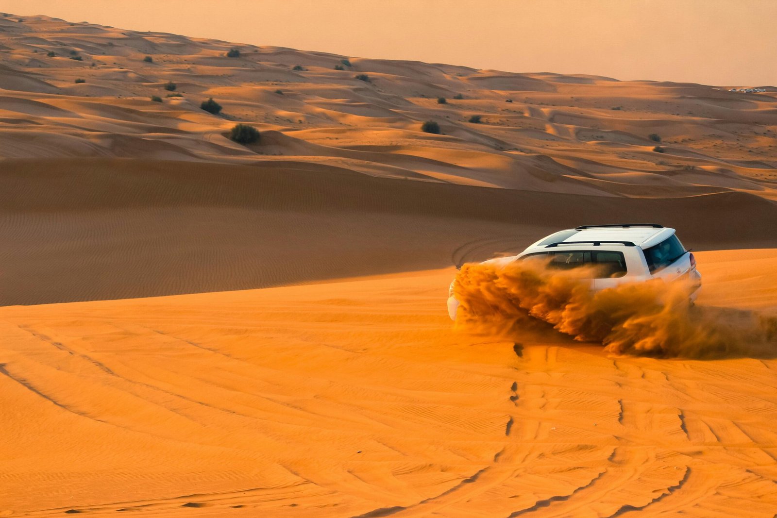 Dubai desert safari adventure with golden sand dunes at sunset and a camel caravan, ideal for an unforgettable Arabian journey.