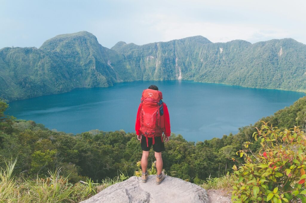 Backpacker enjoying a breathtaking view, illustrating the concept of affordable world travel and budget-friendly adventures.