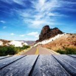 A scenic road winds through the rolling hills of the Texas Hill Country at sunset, an inspiring vista for planning adventurous Texas vacations.