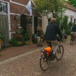 A traveler with a backpack explores a sunny cobblestone street in one of the best European cities to visit for a 2025 adventure.
