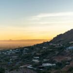 Panoramic view of a beautiful US city skyline from a mountain overlook at sunrise, showcasing one of the most scenic cities in the US.
