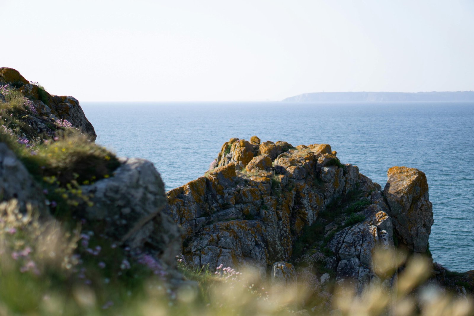 A traveler looking out over a beautiful, sunny coastline, an example of the best place to travel in May for a perfect spring holiday.