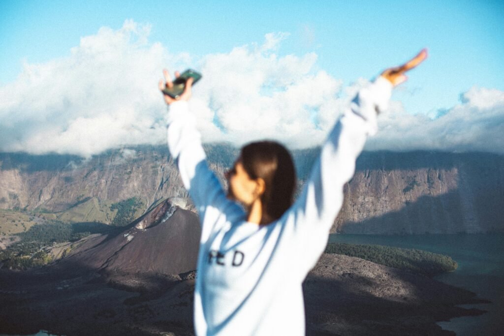 Empowered woman traveler stands confidently in a scenic landscape, symbolizing freedom, self-discovery, and adventure in solo female travel.