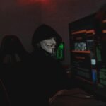 A person viewing a cybersecurity warning on a screen, illustrating the malware and phishing risks of searching for 'ooaris discord nude' content.
