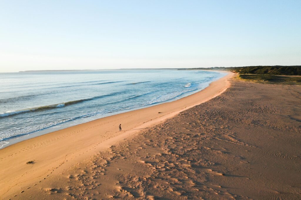 Aerial view of a pristine South Padre Island beach with white sand meeting the turquoise waters of the Gulf of Mexico, the perfect destination for a 2025 vacation.