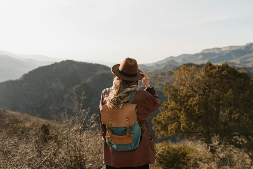 A solo traveler on an affordable package holiday for 2025 stands looking out over a beautiful scenic landscape.