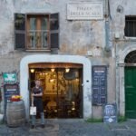 A charming, narrow cobblestone street in the Trastevere district of Rome, one of the city's most touristy areas, shown in the peaceful morning light without crowds.