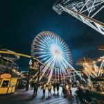 Vibrant scene of Wildwood Boardwalk at sunset, featuring iconic Morey's Piers amusement rides brightly lit, symbolizing peak summer vacation and crucial Wildwood Boardwalk hours.