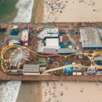 Aerial view of the sunny Wildwood, NJ beach and boardwalk, highlighting the best places to stay for a 2025 vacation.