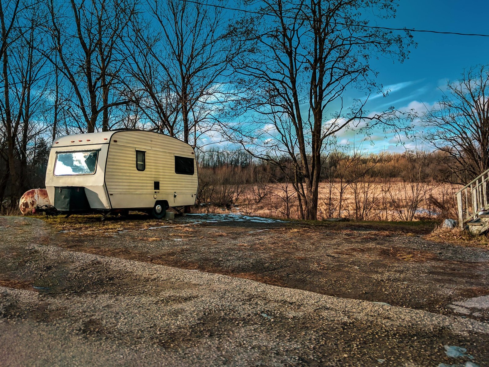 Winterizing a travel trailer: A person pours RV antifreeze into the plumbing system to protect pipes from freezing and prevent damage during cold winter months.