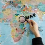 Elegant push pin world map on a wall, adorned with colorful pins marking visited countries and dream destinations, serving as beautiful travel-inspired home decor.
