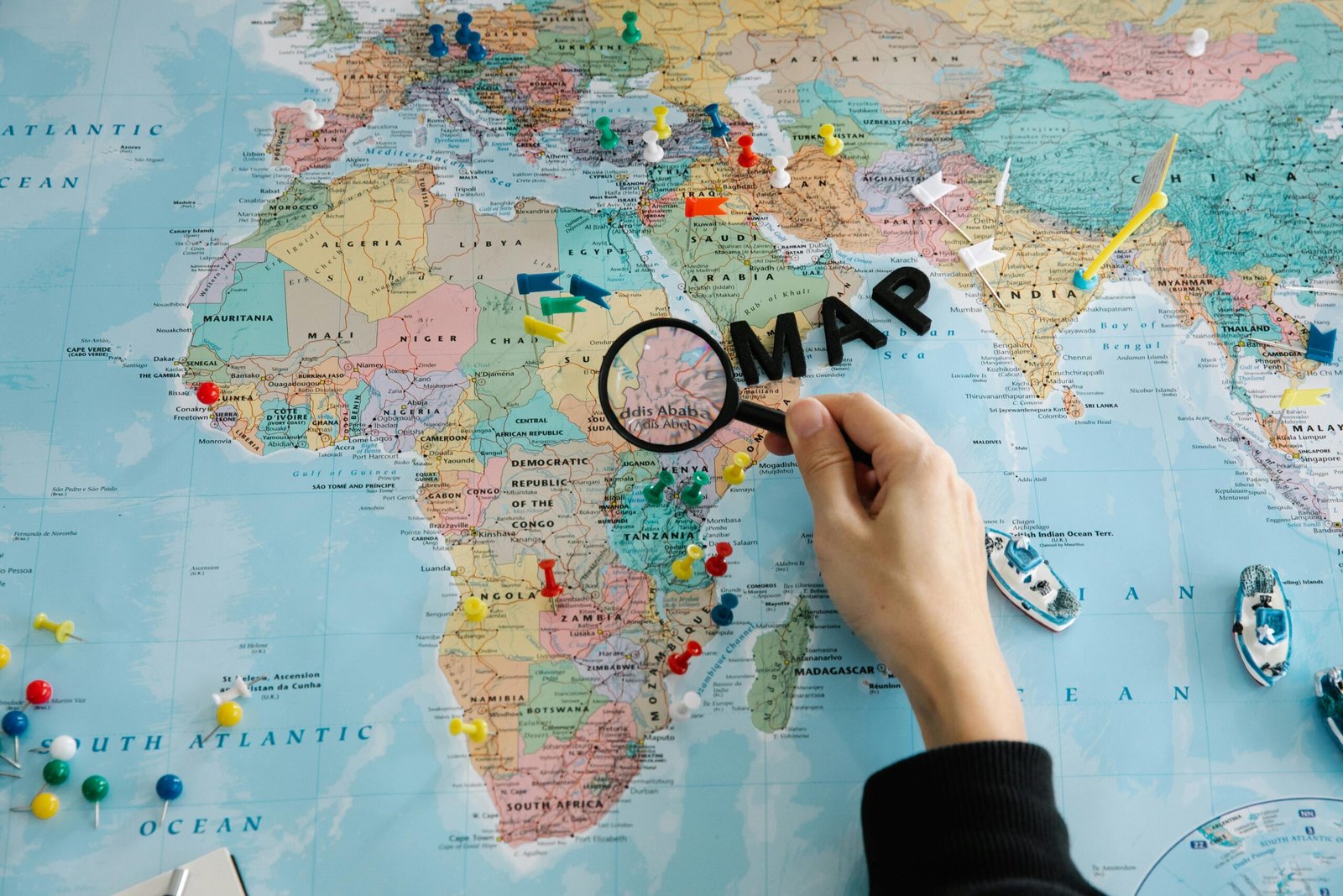 Elegant push pin world map on a wall, adorned with colorful pins marking visited countries and dream destinations, serving as beautiful travel-inspired home decor.